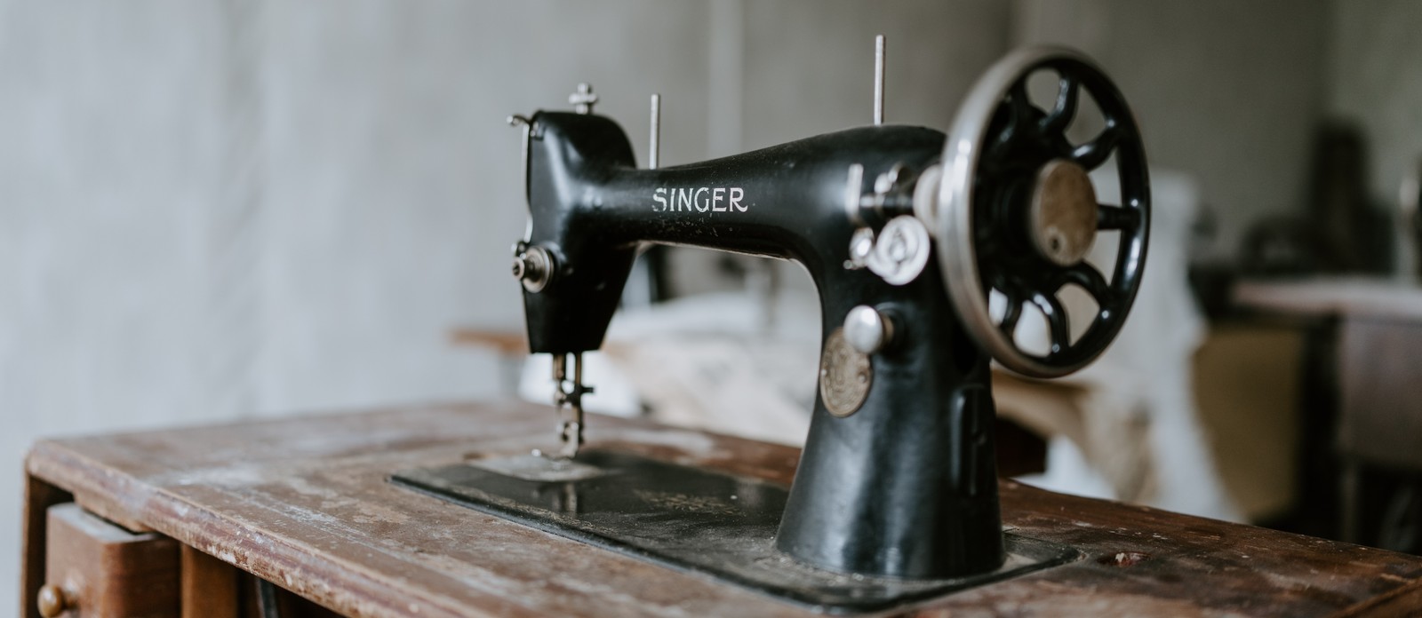 What function does a sewing machine's presser foot serve?